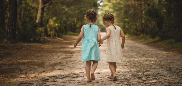 Two little girls walking together by Superelaks
