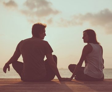 Young couple on dock at sunrise by Diter