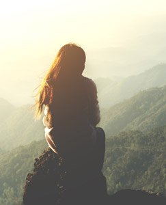 Woman sitting on a ridge at sunrise by Nakedcm