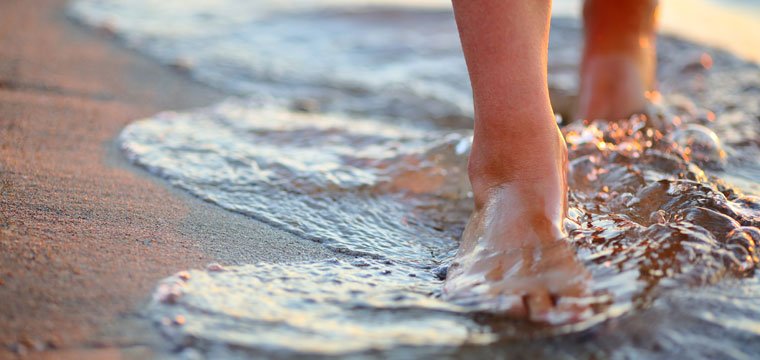 walking bare feet on the beach