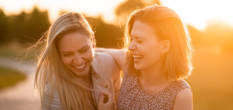 Two friends laughing in the sun